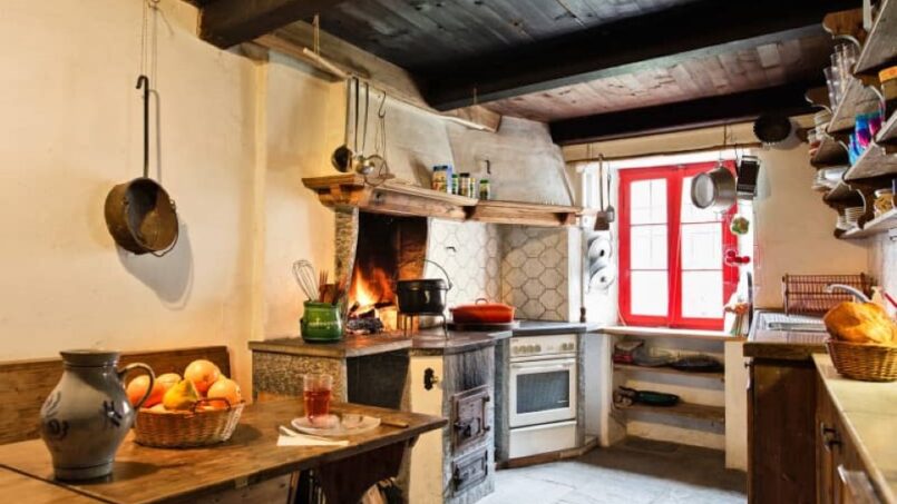 Gruppenhaus A VEJO Hostelleria in Linescio - Küche mit Holztisch, Stühlen und Kamin