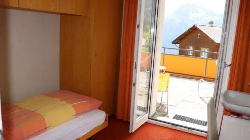 Gruppenunterkunft Adrenalin Backpackers Hotel Braunwald Schlafzimmer mit Bergblick
