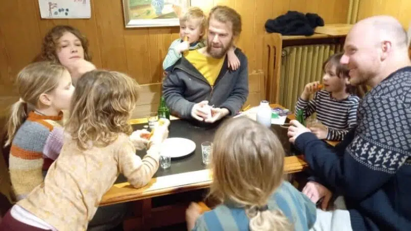 Gruppe von Menschen isst zusammen im Adrenalin Backpackers Hotel Braunwald - Gruppenunterkunft Schweiz