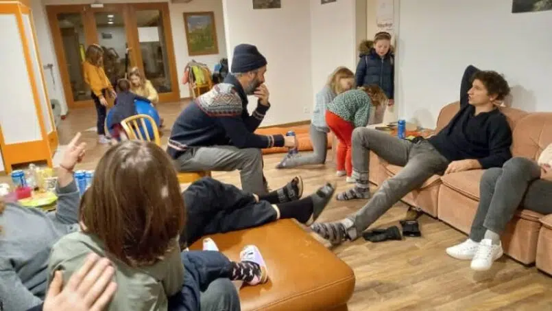 Gruppe von Menschen auf Sofas im Wohnzimmer Adrenalin Backpackers Hotel Braunwald Gruppenunterkunft