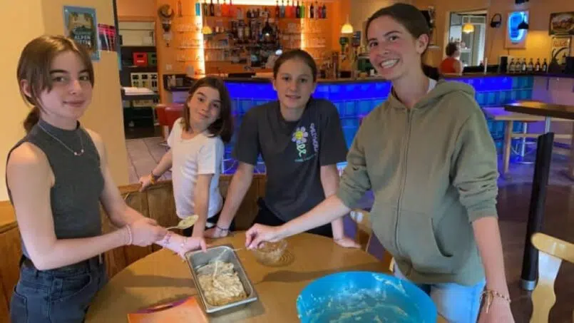 Mädchen-Gruppe bereitet Essen im Adrenalin Backpackers Hotel Braunwald vor - Gruppenunterkunft