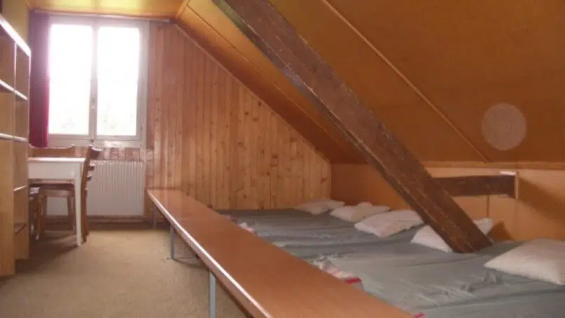 Gruppenunterkunft Haus Alpenblick Schwarzenegg - Zimmer mit Bett und Schreibtisch