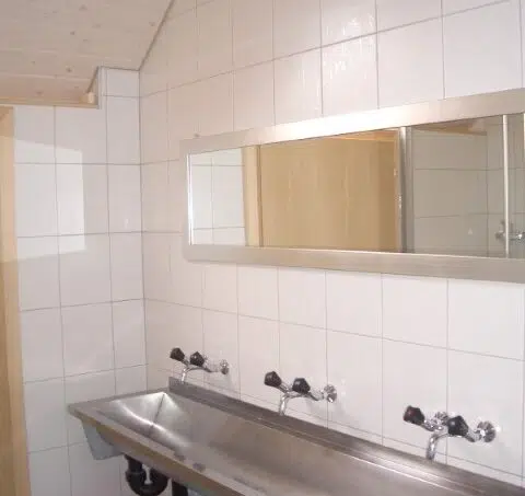 Gruppenunterkunft Haus Alpenblick Schwarzenegg Badezimmer mit zwei Waschbecken und Spiegel