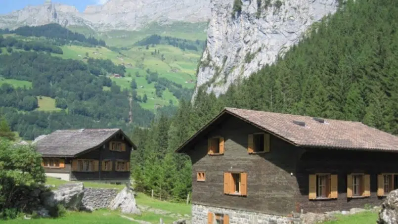Gruppenhaus Bad Brunnital Unterschächen - Holzchalets auf grüner Wiese mit Bergpanorama im Hintergrund