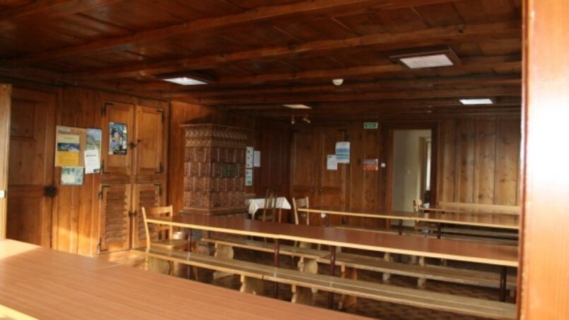 Gruppenhaus-Bellevue-Mont-de-Buttes-Holzzimmer-mit-Holztischen-und-Stühlen