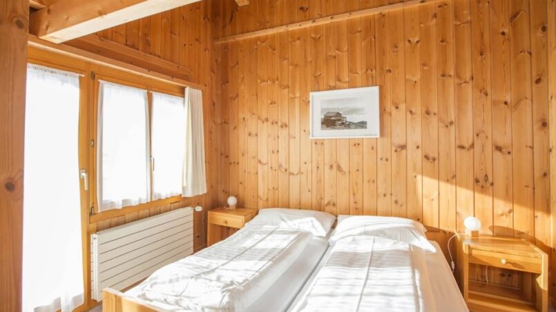 Gruppenhaus Berghaus Nagens Schlafzimmer mit Holzbett und Fenster in Flims