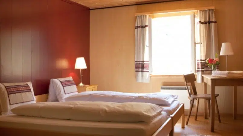 Gruppenhaus-Berghaus-Oberaar-Guttannen-Zimmer-mit-roten-Wänden-und-Bett
