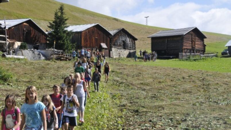 Kindergruppe wandert beim Gruppenhaus Berghaus Planatsch in Sedrun