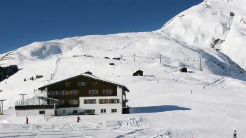 Gruppe Skifahrer beim Abfahrt auf schneebedecktem Berg bei Gruppenhaus Berghaus Planatsch, Sedrun