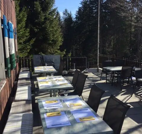 Gruppenhaus Berghaus Ricketschwändi in Kriens mit Outdoor-Essbereich und Schweizer Flagge