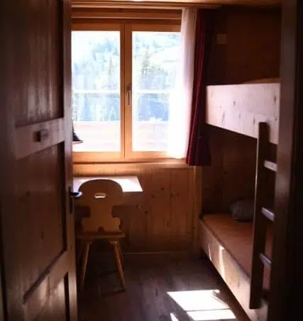 Kleines Zimmer im Blockhaus Duranna Conters i. P. mit Etagenbetten und Schreibtisch - Gruppenunterkunft
