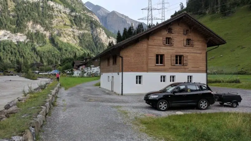 SUV geparkt vor Gruppenunterkunft Cevi-Haus Kandersteg in den Bergen