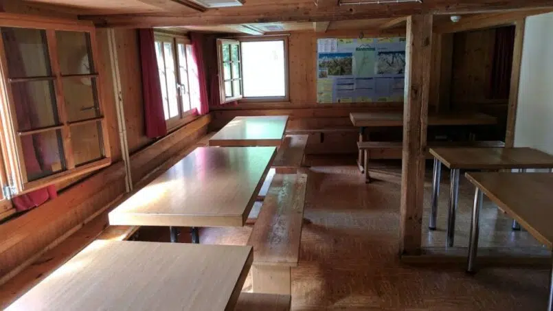 Gruppenunterkunft Kandersteg Cevi-Haus, Raum mit Holztischen und Bänken