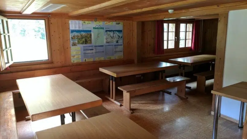 Gruppenunterkunft Cevi-Haus Kandersteg - Schulungsraum mit Holztischen und Bänken