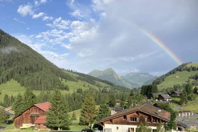 Regenbogen über Bergdorf bei Gruppenunterkunft Chalet Bel-Oiseau in La Lecherette