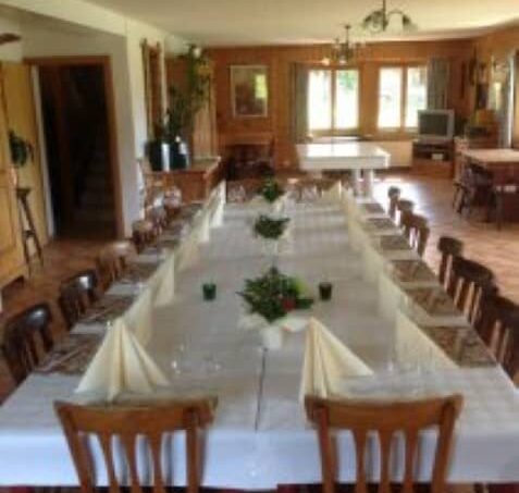 Gruppenunterkunft Chalet Bel-Oiseau La Lécherette grosser Speisesaal mit weissen Tischdecken und Stühlen