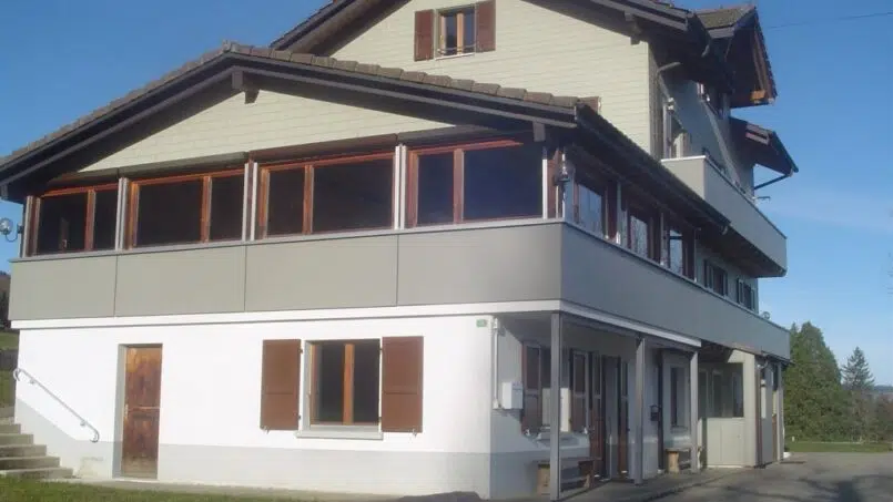 Gruppenunterkunft Chalet de l'Entraide Le Pâquier - Weißes Haus mit braunen Fensterläden