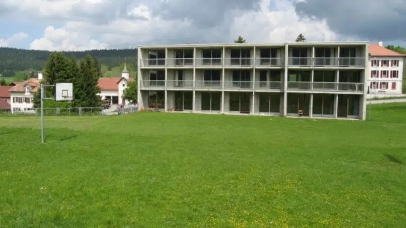 Gruppenunterkunft Echanges Scolaires in Les Bayards - großes Gebäude im grünen Feld