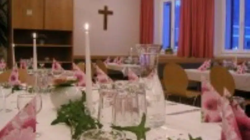 Gruppenunterkunft Erlebnisgästehaus Kanisfluh Bezau gedeckter Tisch mit pinken Blumen und Kerzen