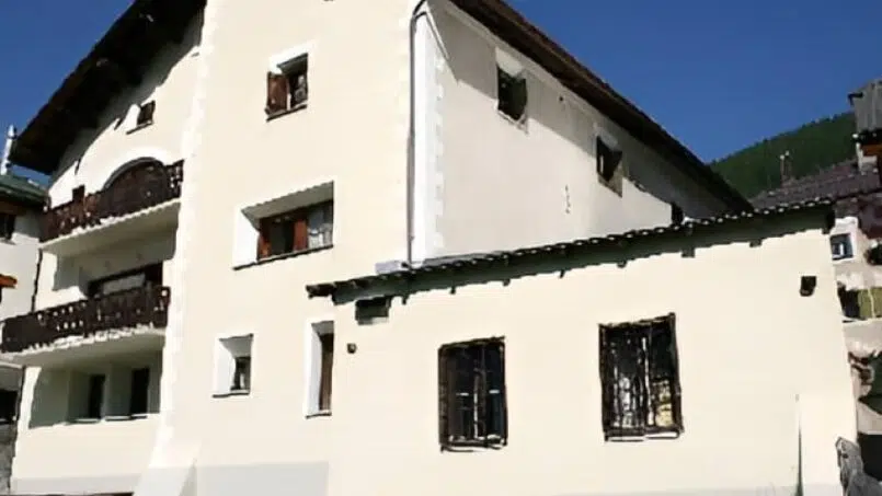 Gruppenunterkunft Ferienhaus Chesa Quattervals S-chanf weisses Gebäude mit Balkonen