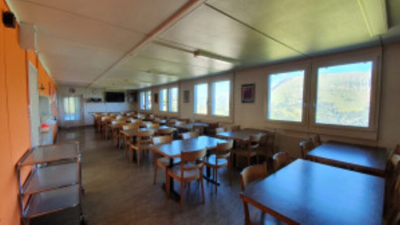 Leerer Speisesaal mit Tischen und Stühlen im Gruppenunterkunft Ferienheim Schrattenblick in Marbachegg