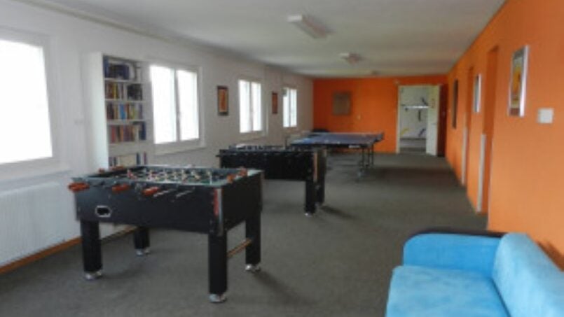 Gruppenunterkunft Ferienheim Schrattenblick Marbach Haupthalle mit Kicker Tischen und Couches