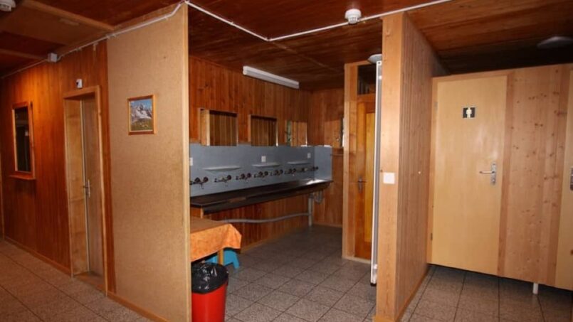 Gruppenunterkunft Ferienlager Putnengia Rueras Badezimmer mit Holzverkleidung und Waschbecken