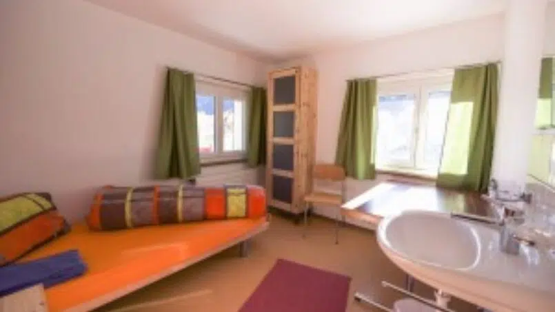 Ferienlager-Splügen-Gruppenunterkunft-kleines-Zimmer-mit-Bett-und-Waschbecken