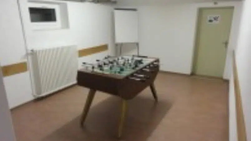 Fußballtisch in leerem Raum im Ferienlagerhaus Trans, Gruppenunterkunft Schweiz
