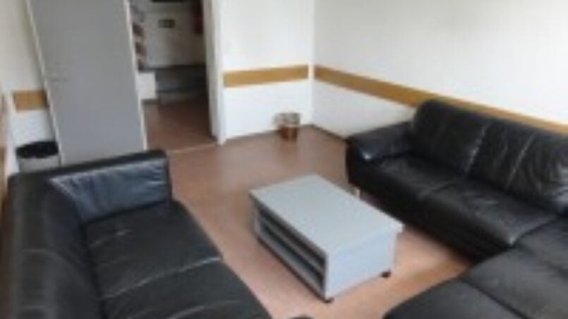 Gruppenunterkunft Ferienlagerhaus Trans, Wohnzimmer mit schwarzen Ledercouches und Couchtisch