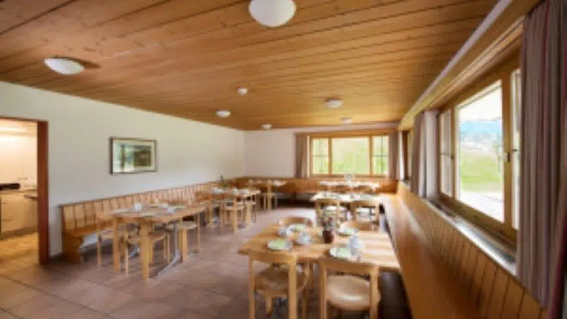 Gruppenunterkunft Gruoberhus Klosters-Dorf, Esszimmer mit Holztischen und -stühlen