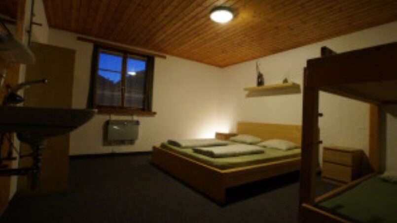 Kleines Zimmer mit Etagenbetten und Waschbecken im Gruppenhaus Rheinquelle Sedrun - Gruppenunterkunft