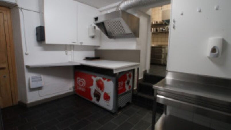Kleine Küche mit Kühlschrank und Spüle im Gruppenhaus-Hotel Rheinquelle, Sedrun - Gruppenunterkunft