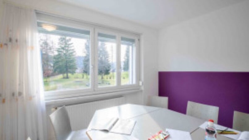 Gruppenhaus SJBZ Einsiedeln mit lila Wänden und weißem Tisch