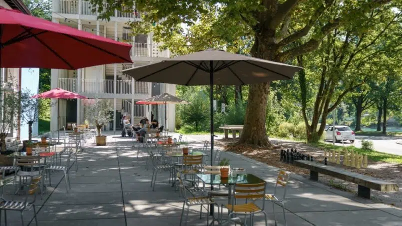 Outdoor-Patio mit Tischen und Sonnenschirmen in der Jugendherberge Bern