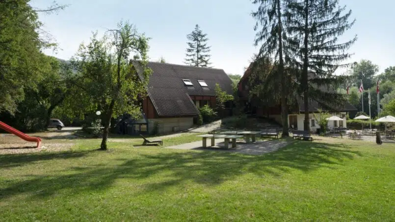 Jugendherberge-Delémont-Haus-mit-Spielplatz-im-grünen-Feld