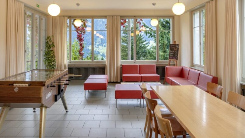 Jugendherberge-Grindelwald-Zimmer-mit-Tisch-und-Stühlen
