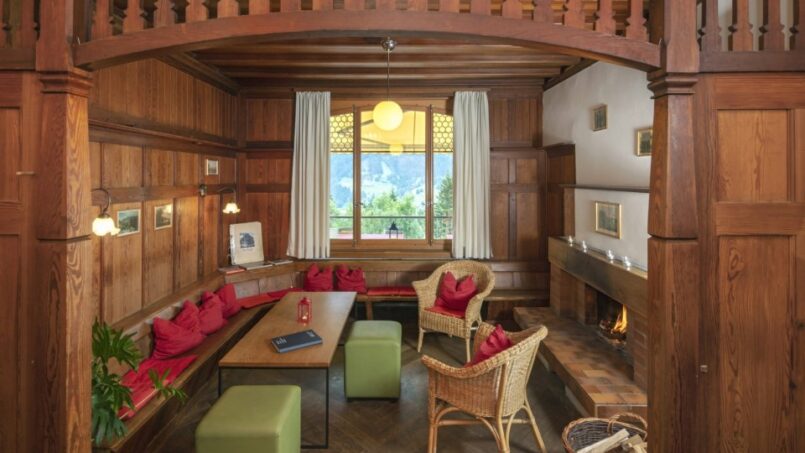 Jugendherberge-Grindelwald-Wohnzimmer-mit-Holzwänden-und-Kamin