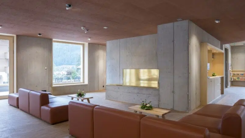Jugendherberge Gstaad Saanenland Wohnzimmer mit Couch und Kamin