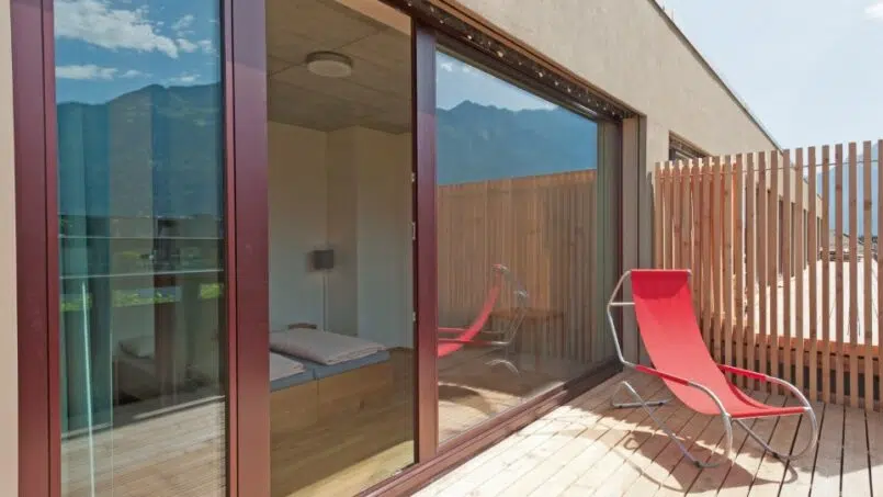 Roter Stuhl auf Balkon der Jugendherberge Interlaken mit Bergblick