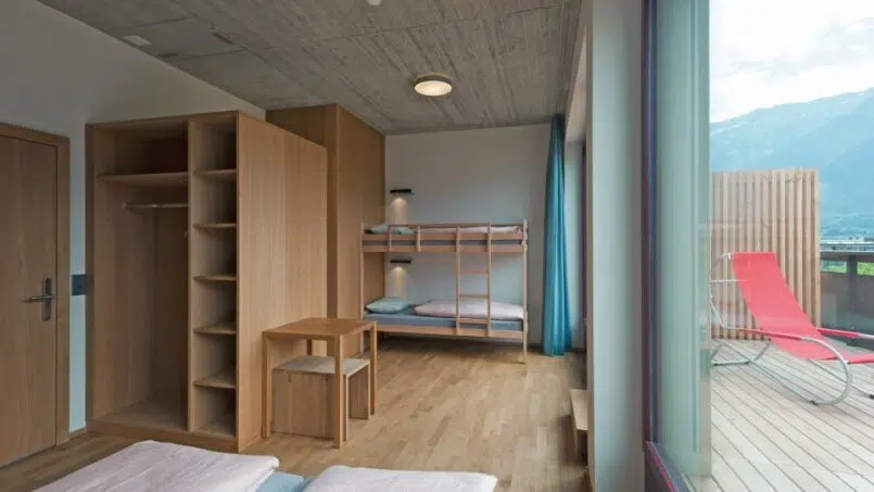Zimmer mit Etagenbetten in der Jugendherberge Interlaken mit Balkonausblick auf die Berge