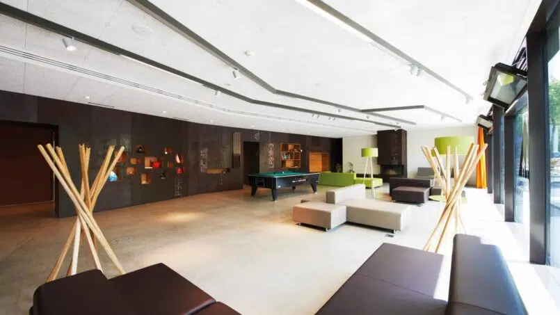 Moderne Lobby der Jugendherberge Interlaken mit Billardtisch und Lounge Stühlen