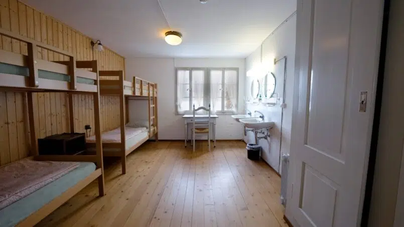 Kleines Zimmer mit Etagenbetten und Waschbecken in der Jugendherberge Leissigen