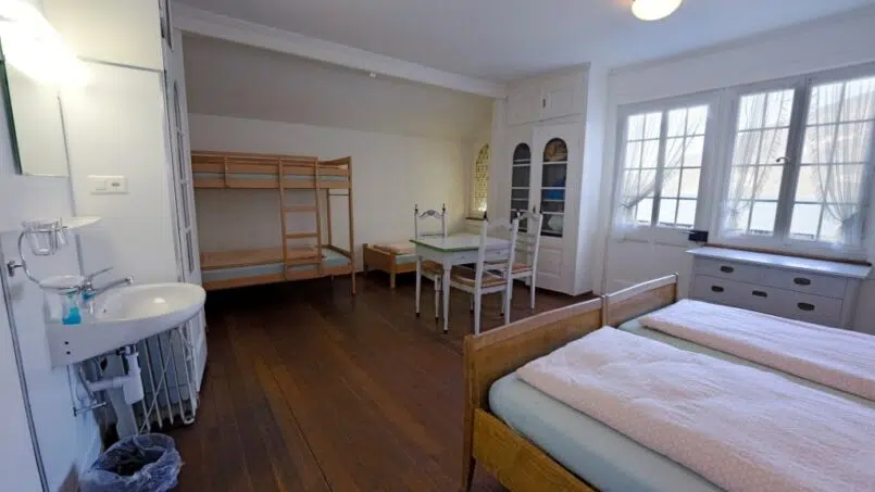 Kleines Zimmer mit Etagenbetten und Waschbecken in der Jugendherberge Leissigen