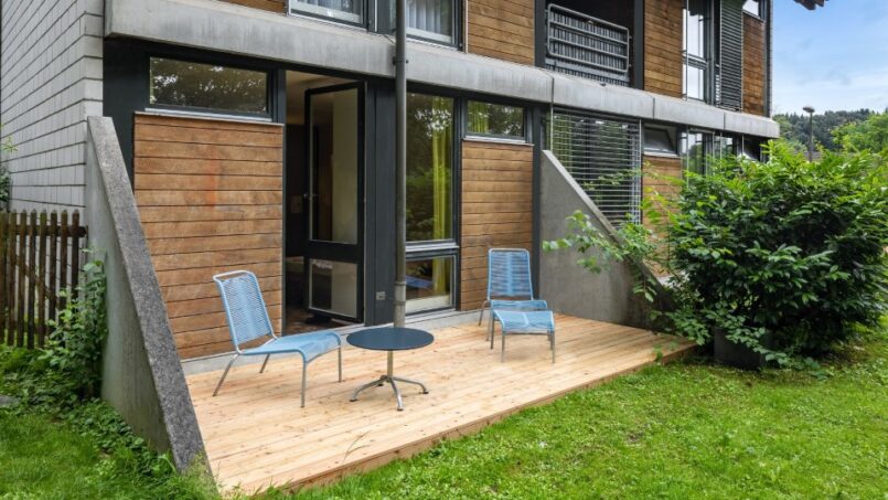 Jugendherberge Luzern Apartmentgebäude mit Holzdeck und Stühlen