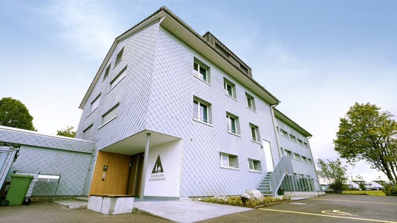 Jugendherberge-Rapperswil-Jona-Gebäude-mit-Treppe-und-Parkplatz-in-Jona