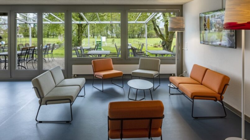 Orange Stühle und Tische im Wartezimmer der Jugendherberge Rapperswil-Jona in Jona