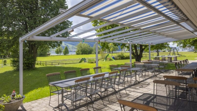 Überdachte Terrasse Jugendherberge Rapperswil-Jona Tische Stühle Grünanlage