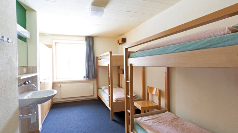 Kleines Zimmer mit Etagenbetten und Waschbecken in der Jugendherberge St. Moritz-Bad