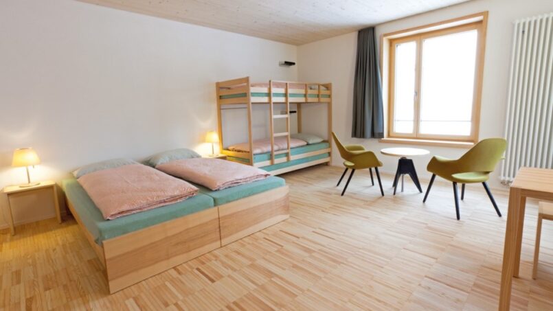 Jugendherberge St. Moritz-Bad Zimmer mit Etagenbetten und Schreibtisch